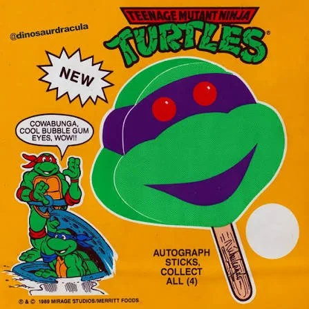 Young Teenage Mutant Ninja Turtles character with large purple eyes, smiling and biting on an orange popsicle stick. The background is orange. The image includes playful text and graphics, with a white starburst shape labeled "NEW," a speech bubble s