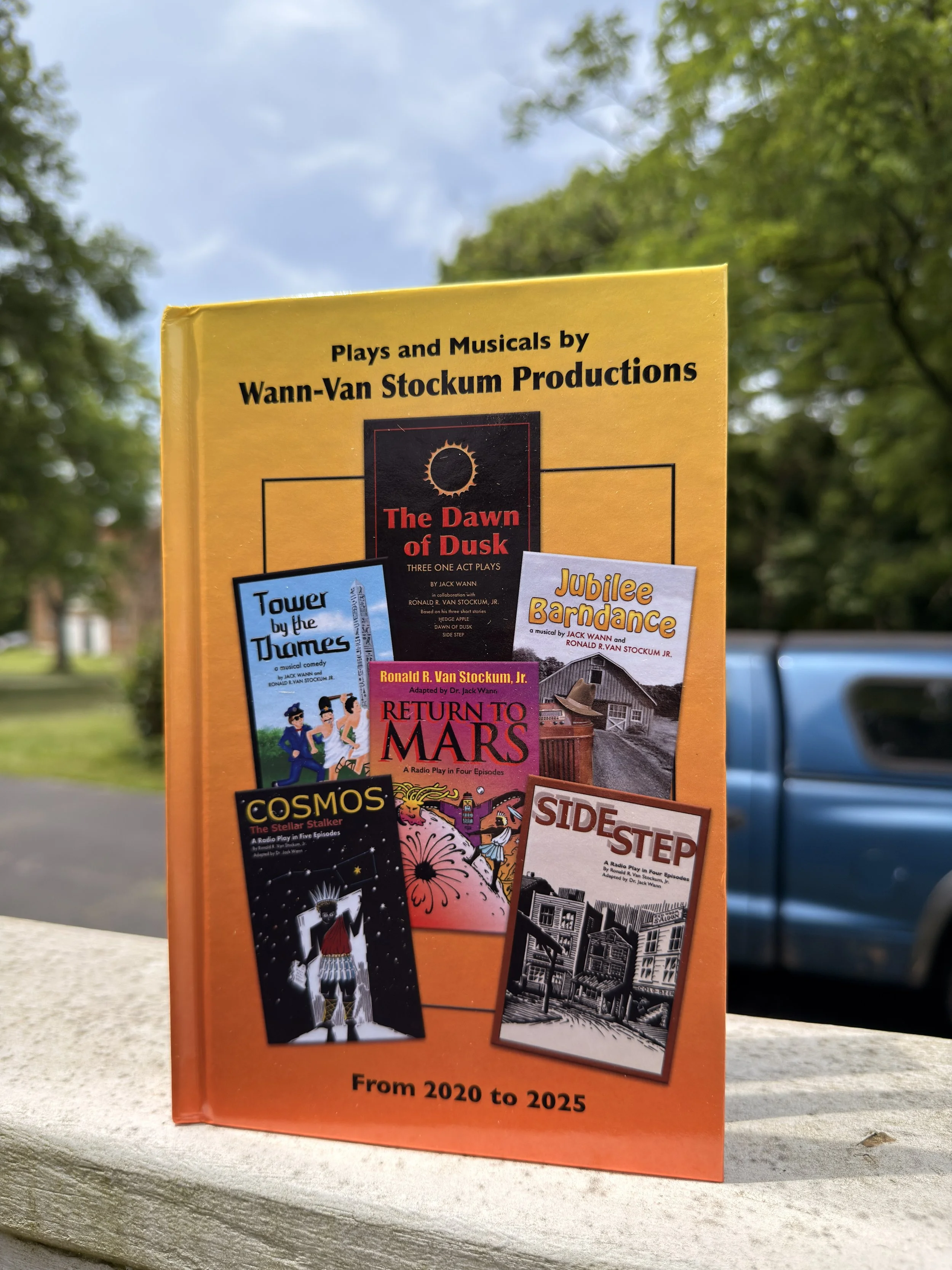 The image plays and musicals by Wann-Van Stockum Productions, including 'The Dawn of Dusk,' 'Tower by the Thames,' 'Jubilee Bardance,' 'Return to Mars,' 'Cosmos,' and 'Side Step,' with a city house in the background and a blue vehicle on the street.