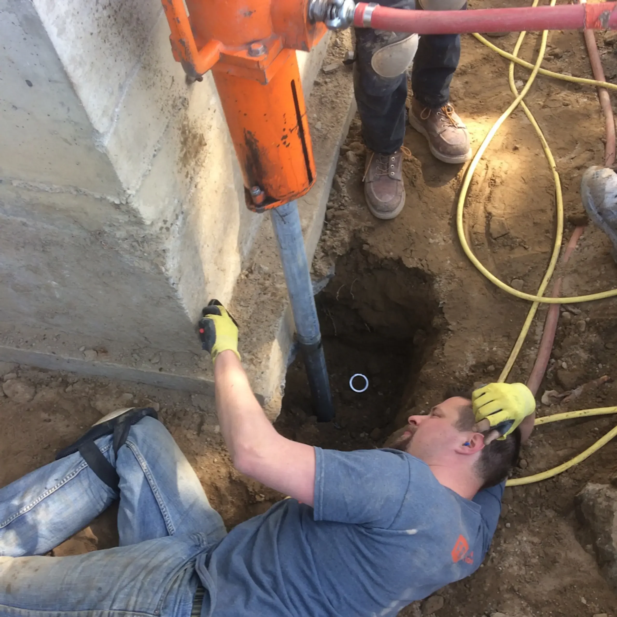 Construction personnel using a power trowel at a project site.