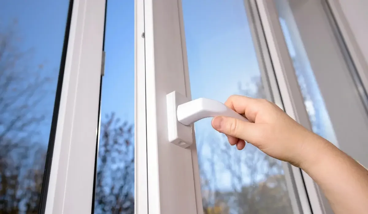 Hand struggling with a stiff window latch