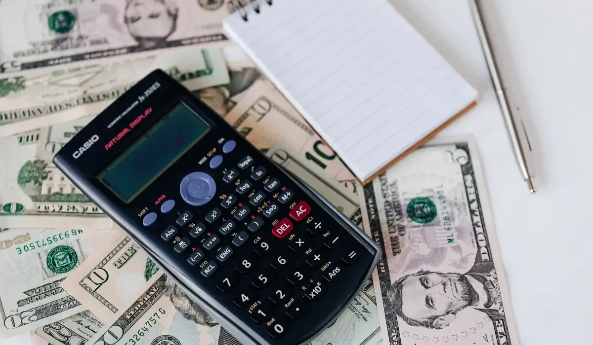 Calculator and cash weighing the cost of basement water damage