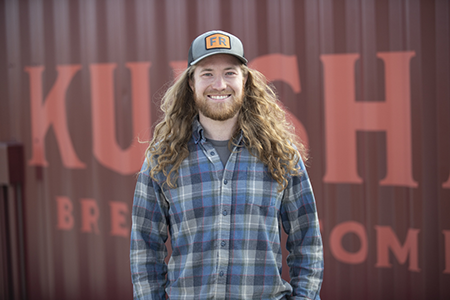 David in front of a red wall with large red letters.