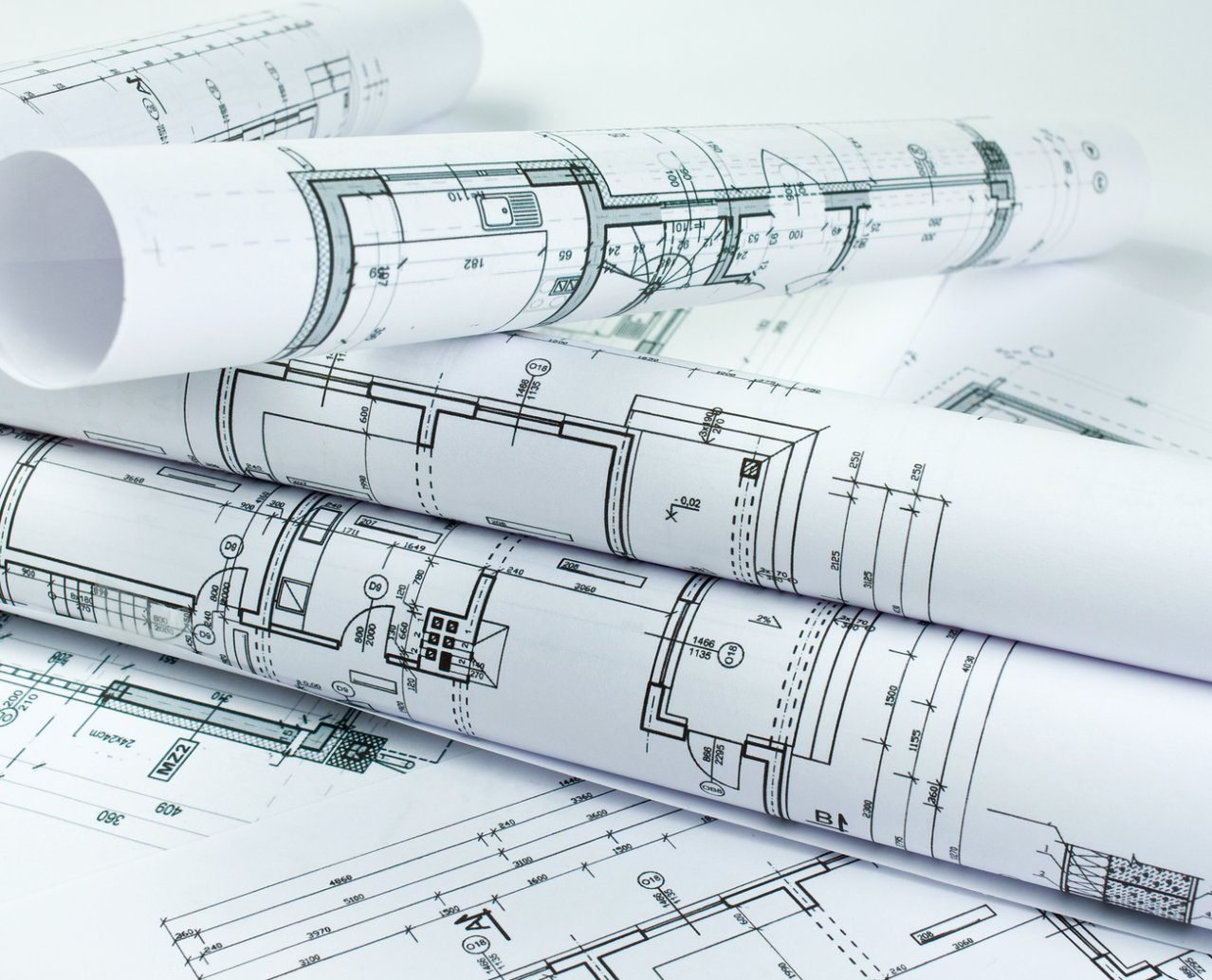 Rolled architectural blueprints showing floor plans with detailed measurements and design elements.