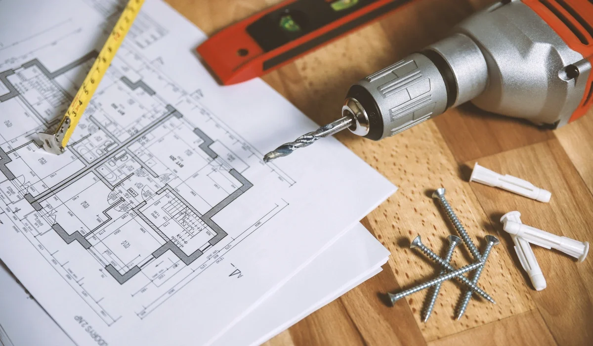 House leveling project plans with a tape measure, level, and drill during the inspection and estimate stage