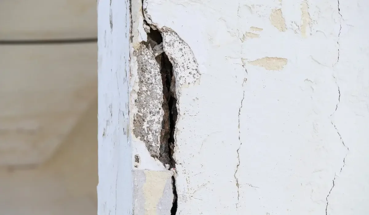 Damaged concrete pillar with deep cracks and crumbling surfaces, highlighting signs of structural deterioration that may require concrete repair or replacement.