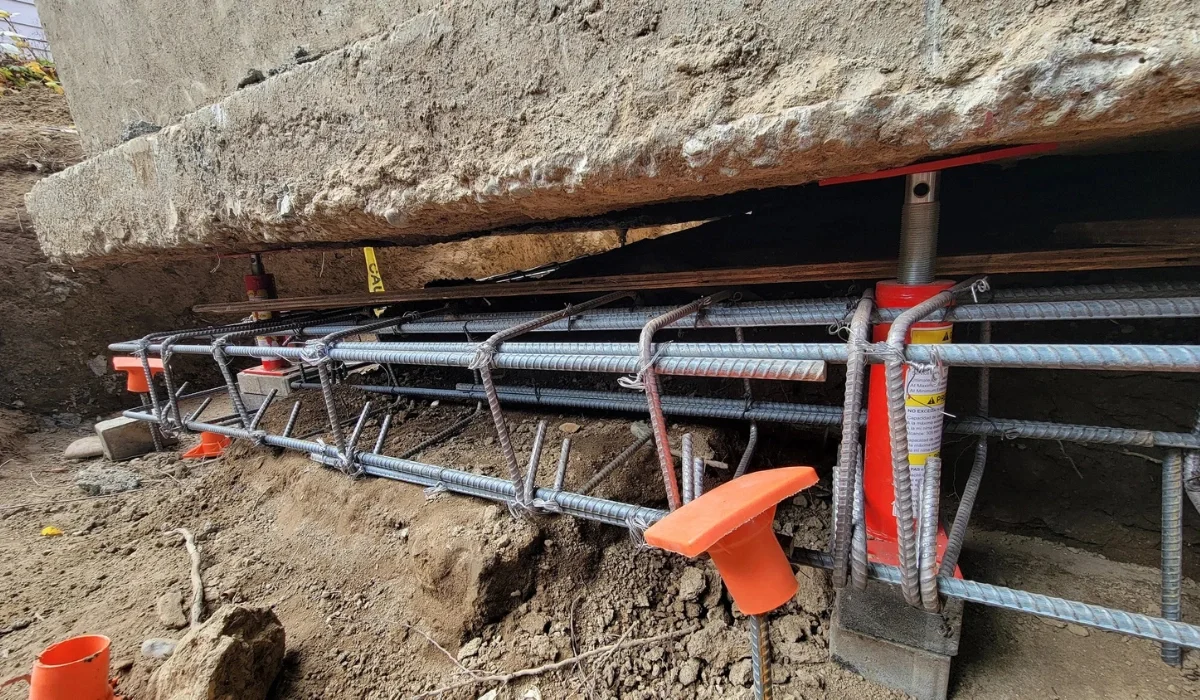 Hydraulic jacks and rebar cage supporting a concrete foundation during a house leveling lift
