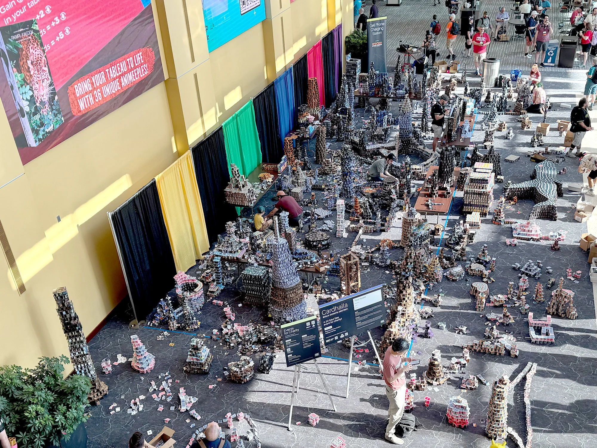 High angle view of the "Cardhalla" card-stacking charity event at Gen Con 2026 at it is being constructed inside the Indianapolis Convention Center
