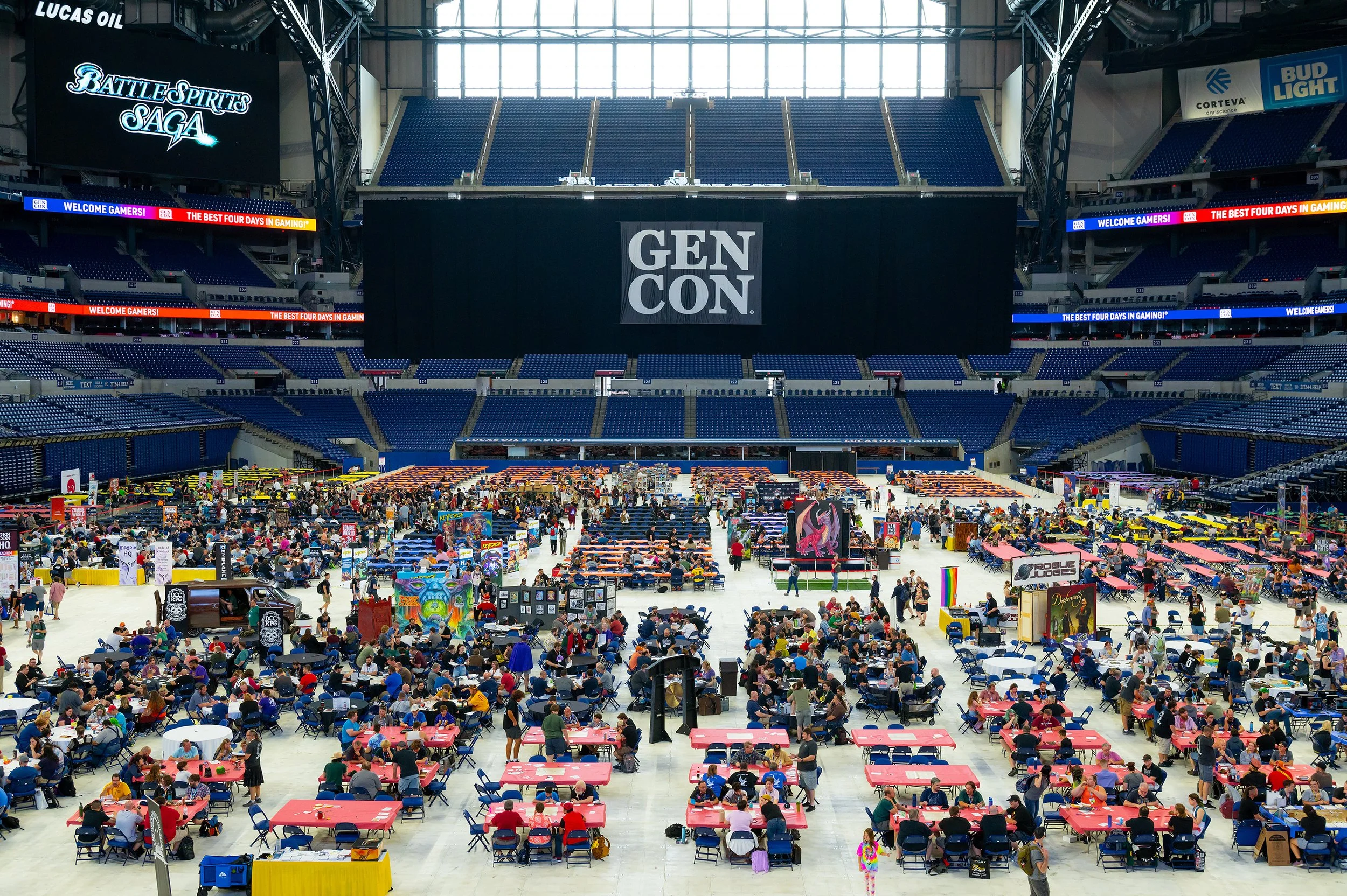 Photo of the interior of the Lucas Oil Stadium filled with people playing tabletop games as well as game vendors.