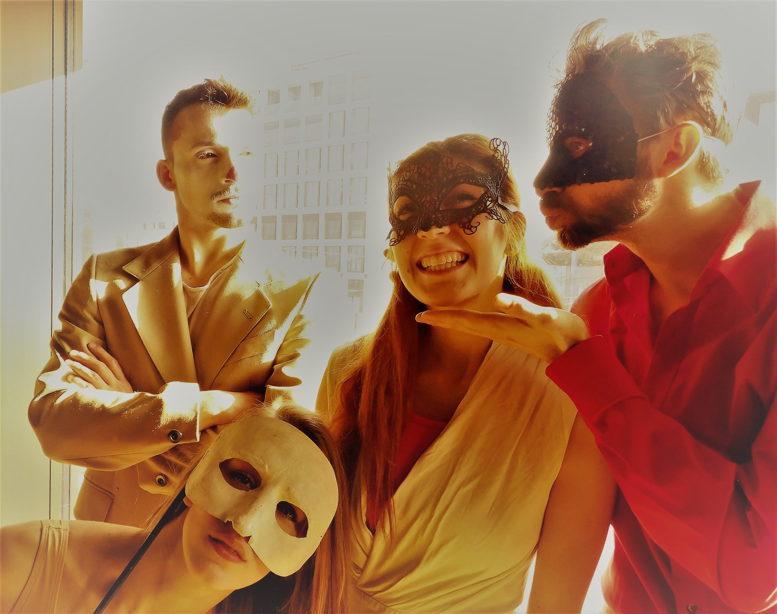 Three people wearing masks, one with a cat mask, one with a lace mask, and one with a plain mask, in a brightly lit indoor space.