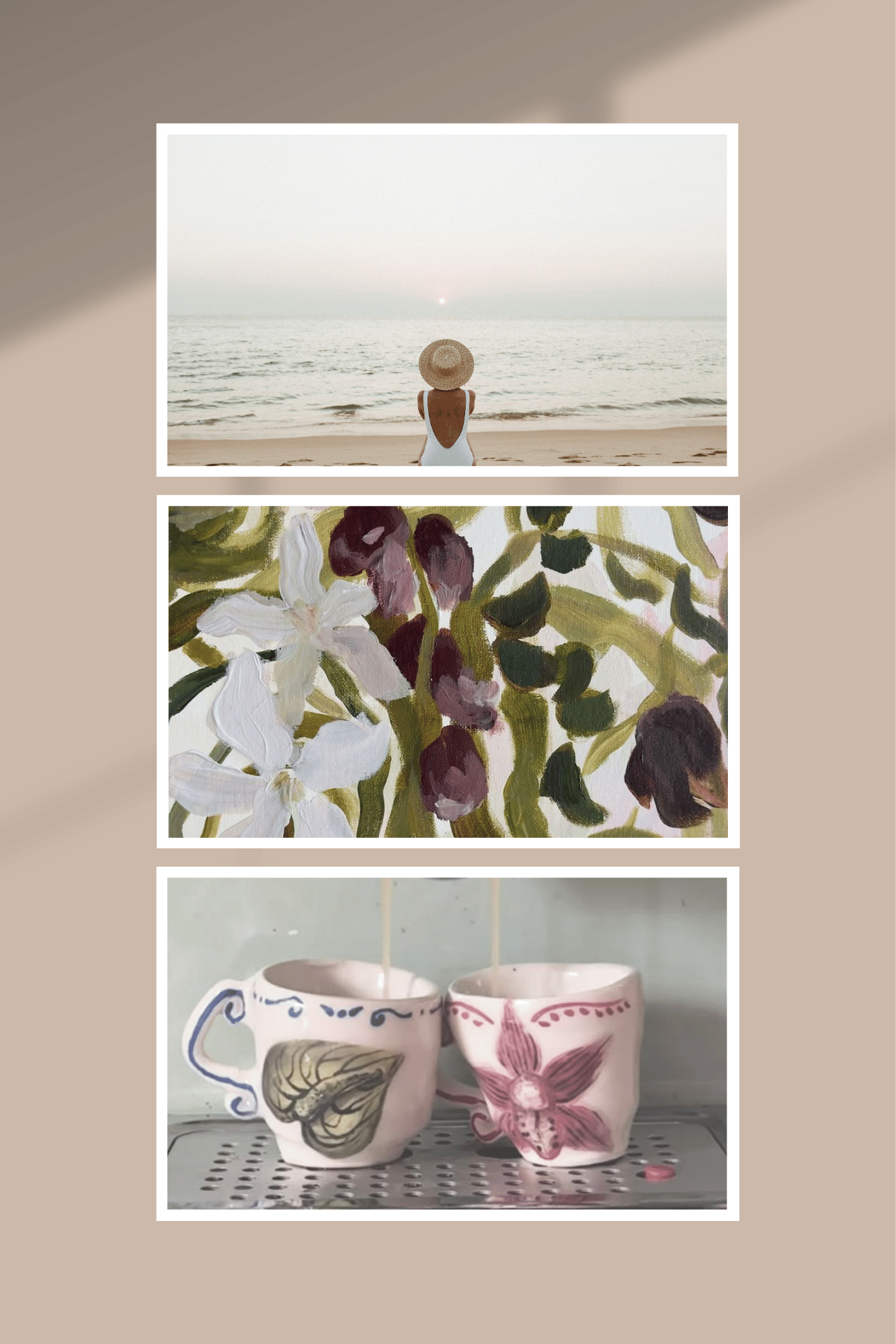 A woman in a white swimsuit and wide-brimmed hat sits on a beach facing the ocean at sunset, with a painting of flowers above and two flowering ceramic cups below.