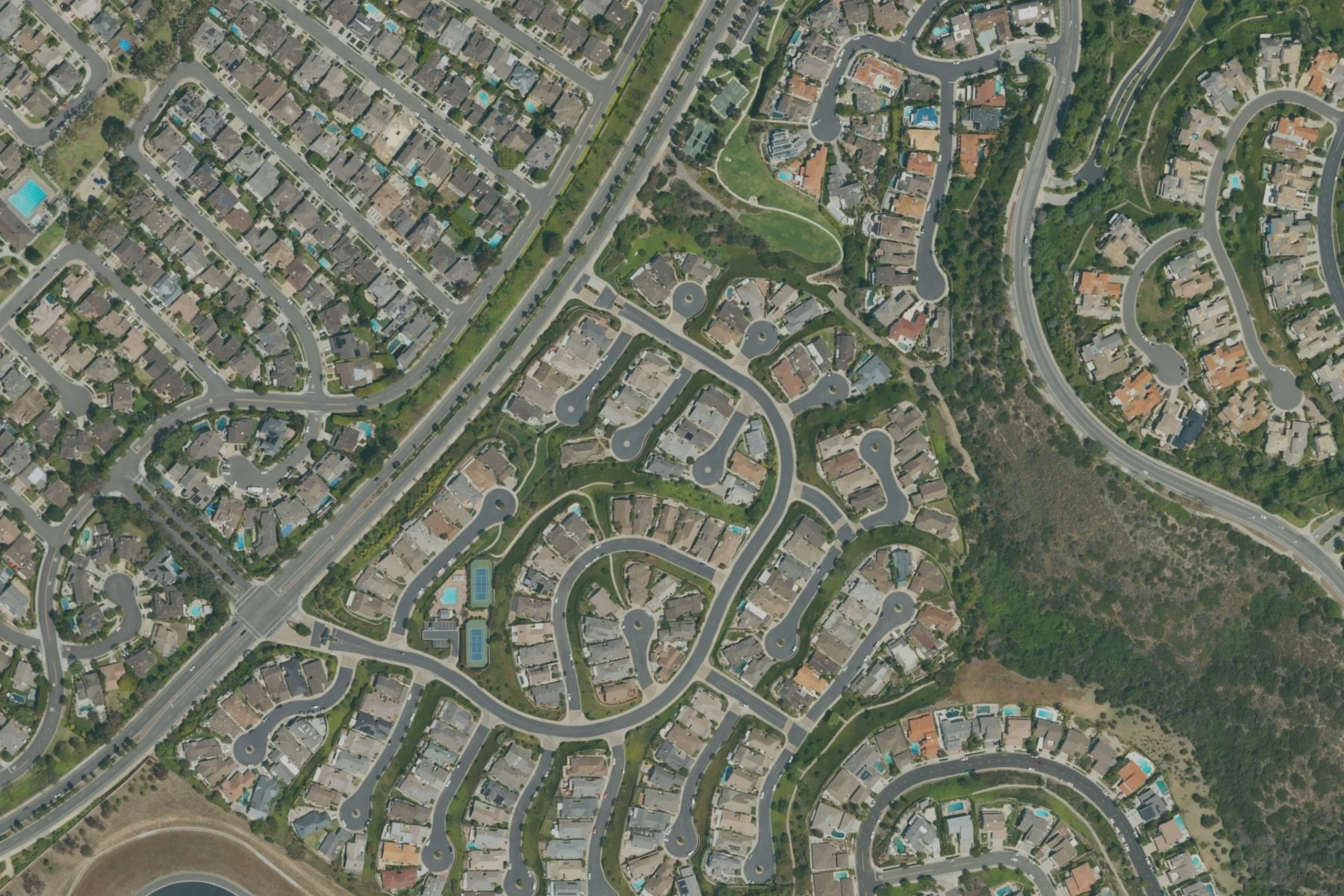 2022 aerial view of Broadmoor Sea View Yacht streets, pool and tennis courts in Newport Beach.