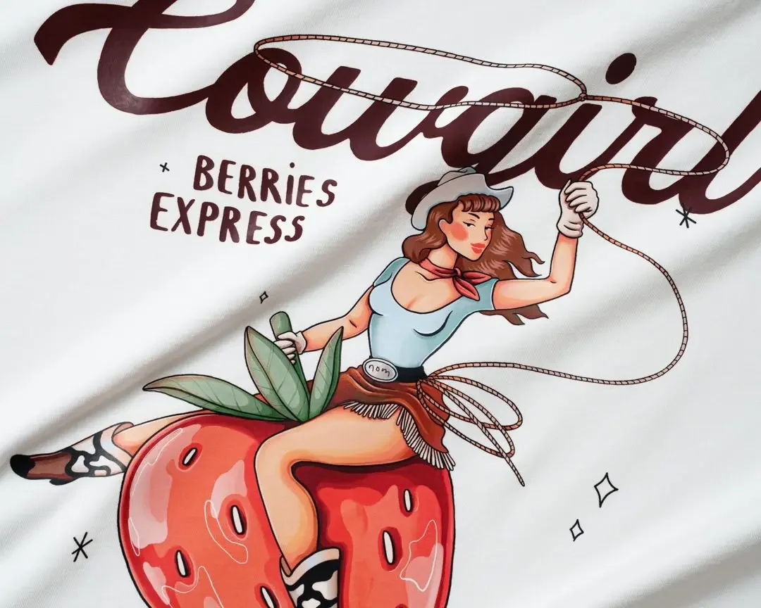 Illustration of a woman dressed as a cowgirl riding a large strawberry, holding a lasso in her right hand, with the words 'Fabulous Berries Express' above her.