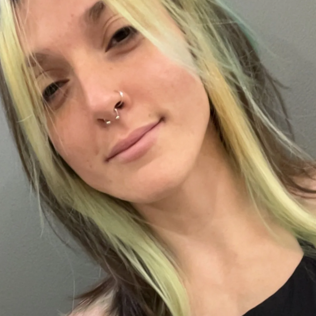 Close-up of Mya, the founder of Rivers & Peonies Events, with blond frontal highlights and otherwise brown hair, smiling subtly.