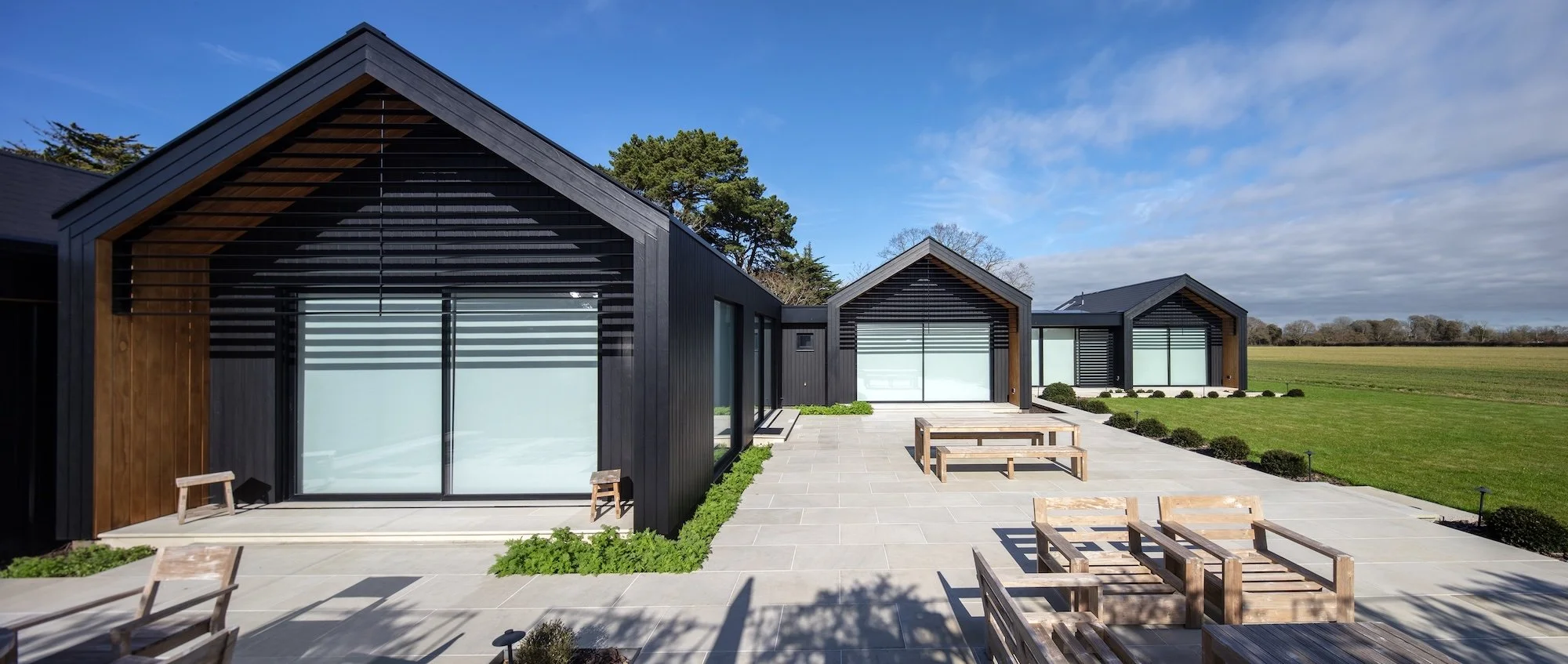 modern-black-timber-pavilions-sandstone-terrace-birdham.jpeg