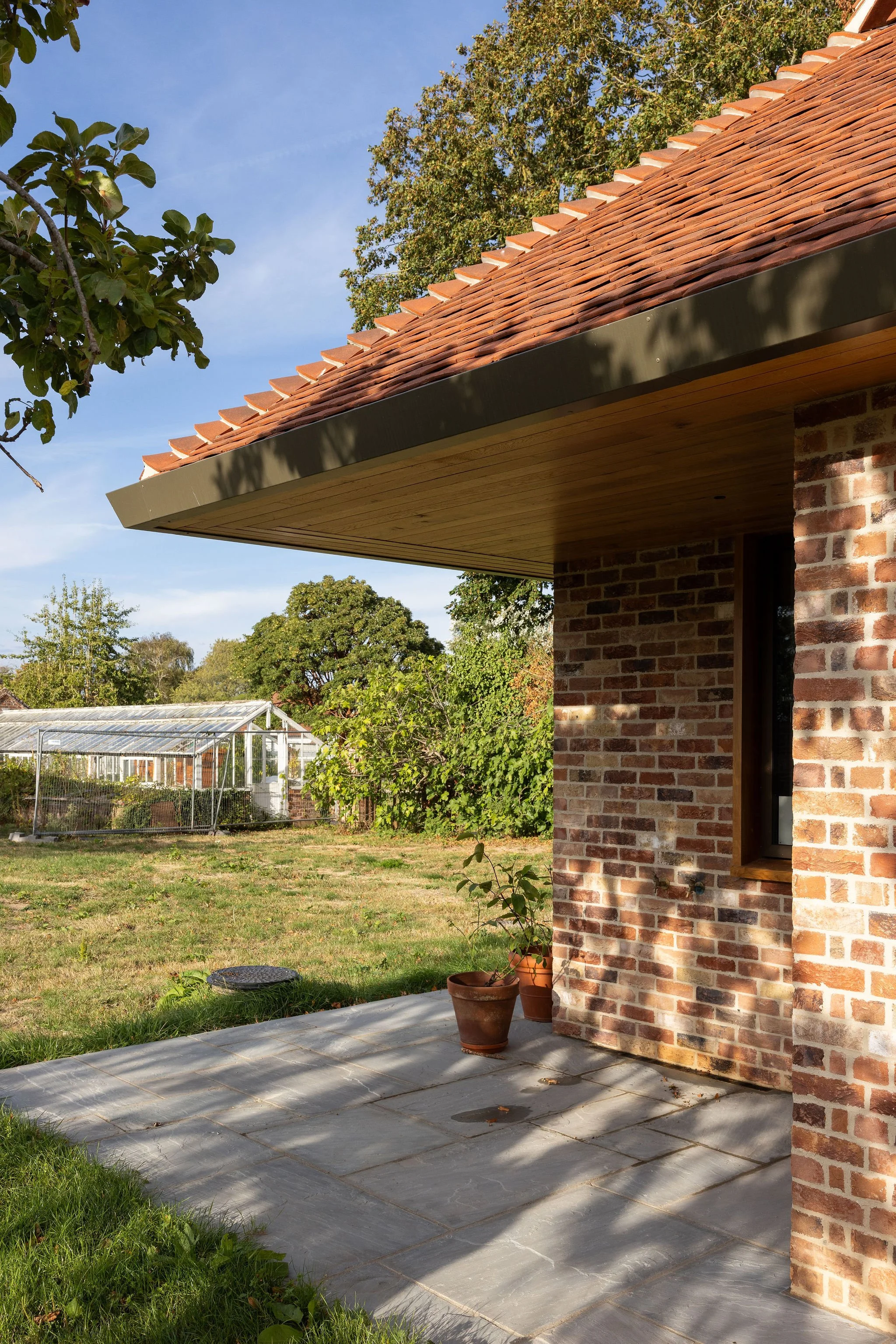wscb-sips-timber-soffit-stone-patio-reclaimed-brick-bosham.webp