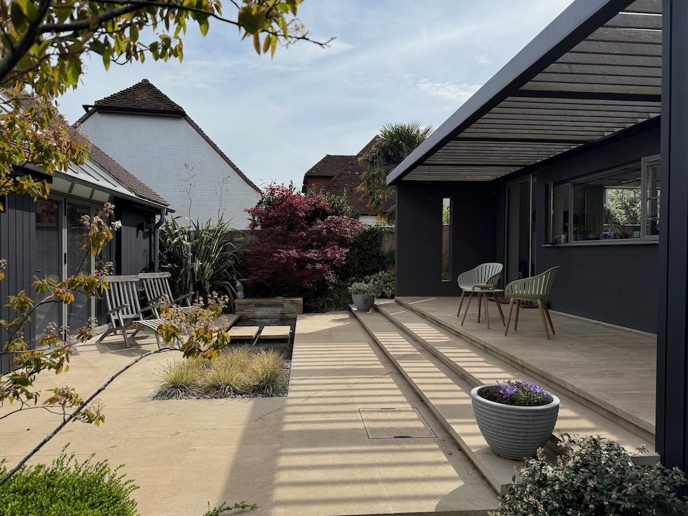 tiered-paved-terrace-pergola-water-feature-bungalow-renovation.jpeg