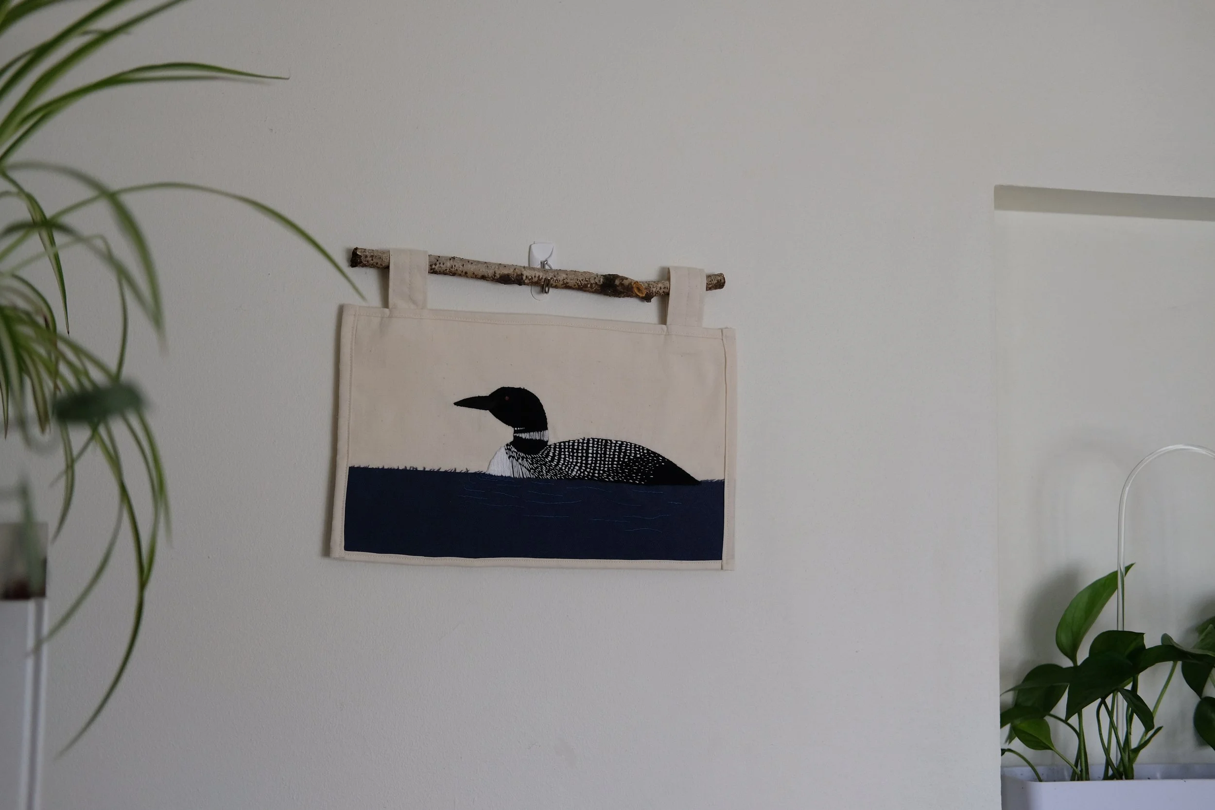 Hand-stitched Loon Art. Embroidered with muslin, included birch branch hanger. 