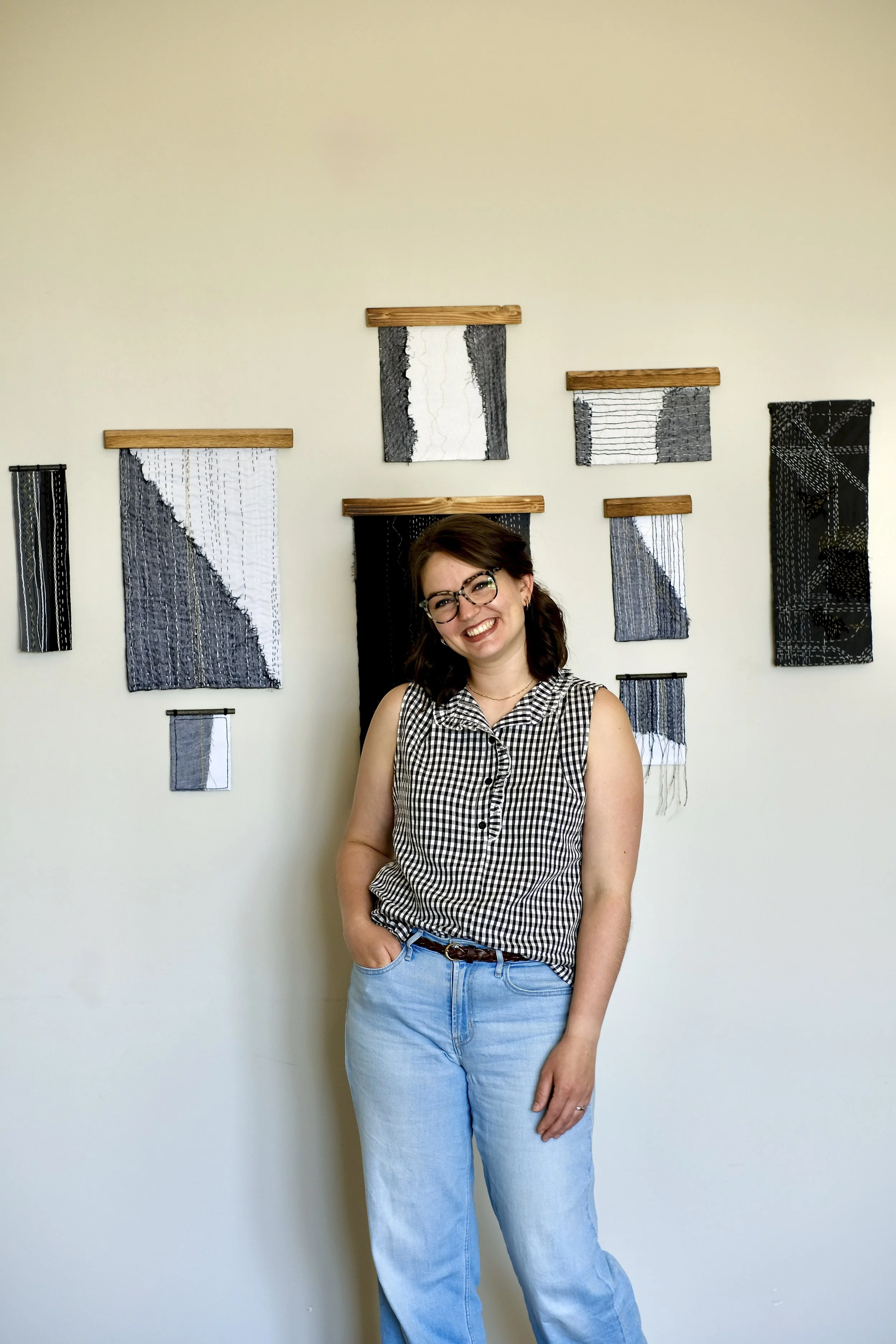 Larch Street Studio Artist Sarah Kirby displaying Loose Threads hanging textile art pieces in shades of black, white, and gray.