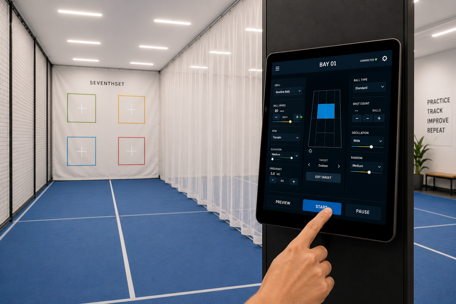 A person operating a tablet with a control interface for a sports simulation in an indoor sports facility with a blue court and a white wall with targets labeled Seventh set.