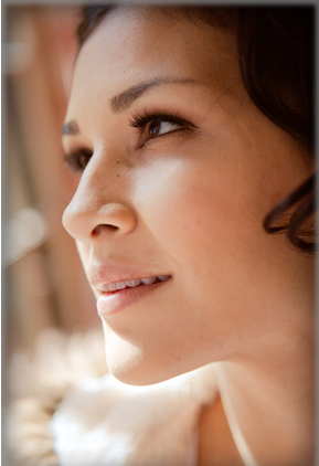 Close-up of a woman's face, showing her profile and smiling slightly.