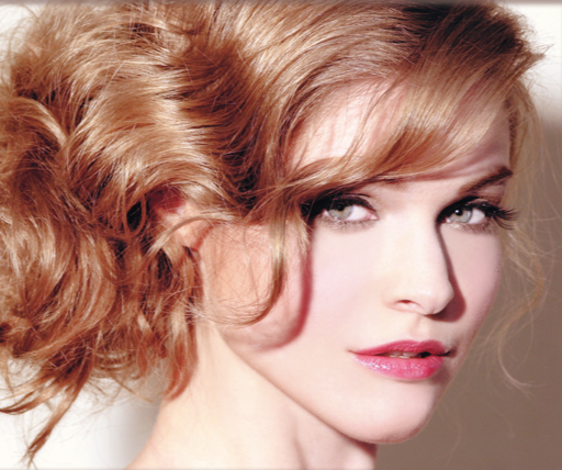Close-up portrait of a woman with red hair and light makeup, looking to the side.
