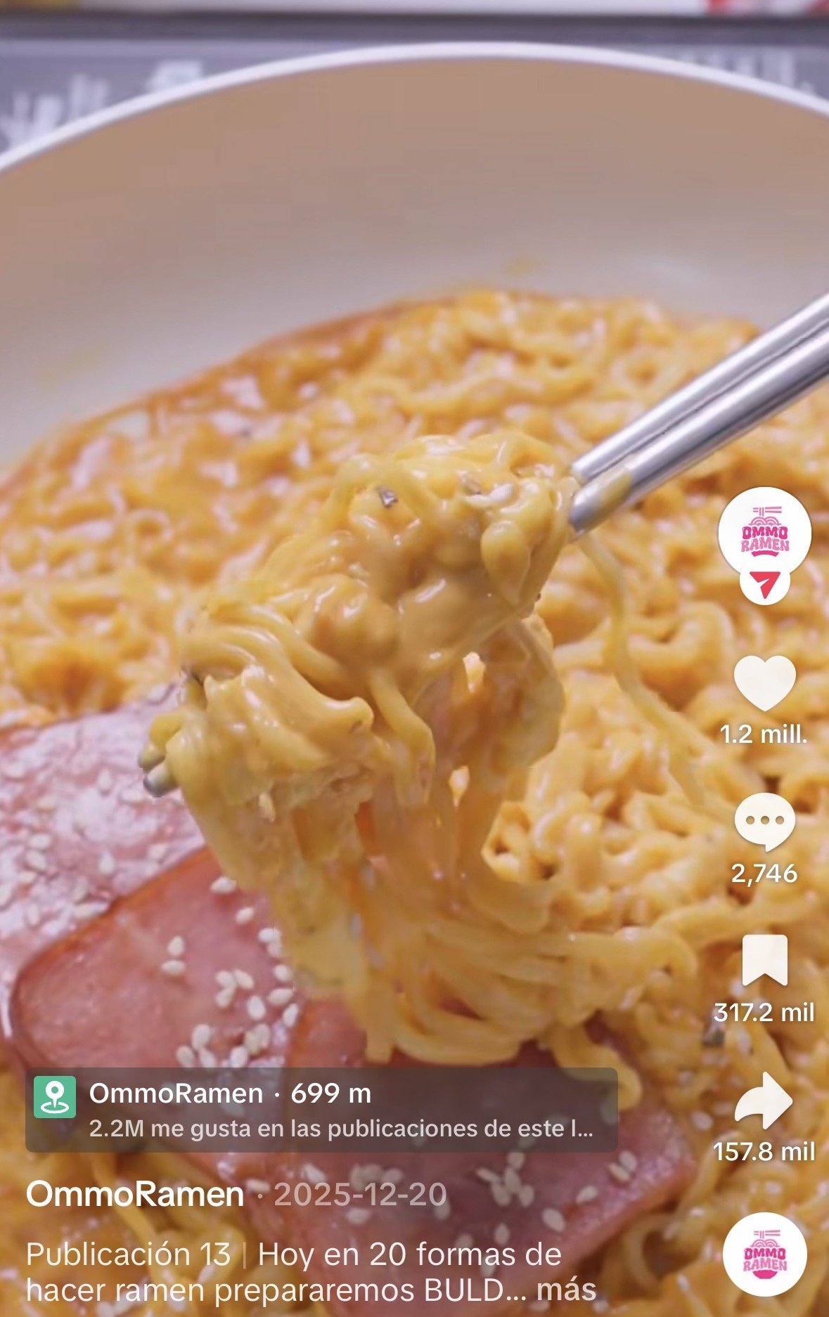 Tazon con fideos ramen con salsa cremosa, con algunos ingredientes visibles como carne y semillas de sésamo.