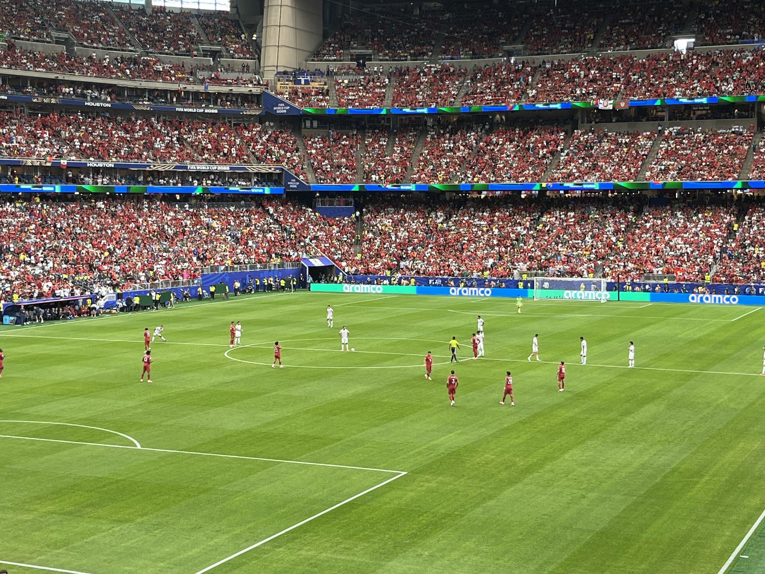 A soccer stadium filled with spectators, with players on the field during a match.