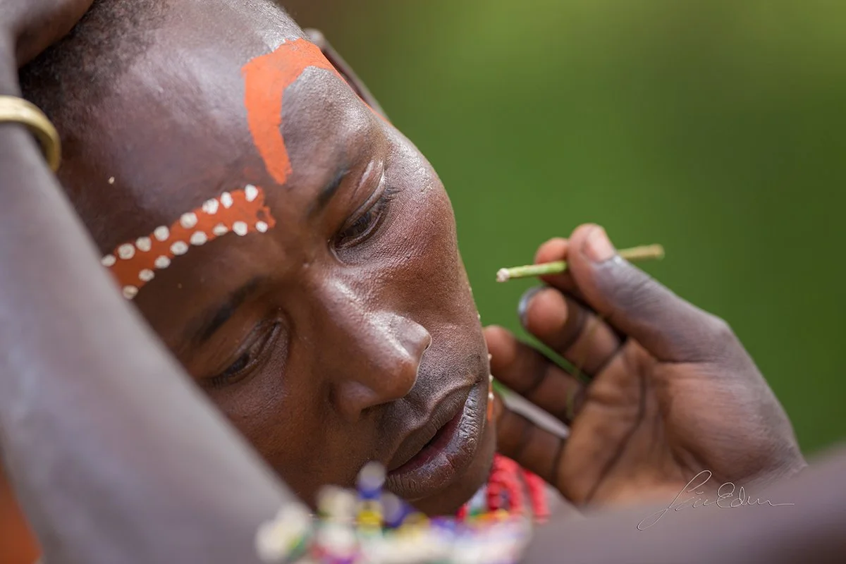 A friend of the groom gets a face paint before the wedding.