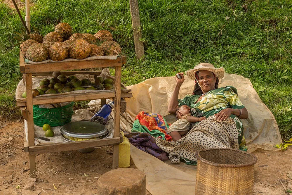 "Saleswoman resting while posing", Rubuguri town, Kisoro, Uganda