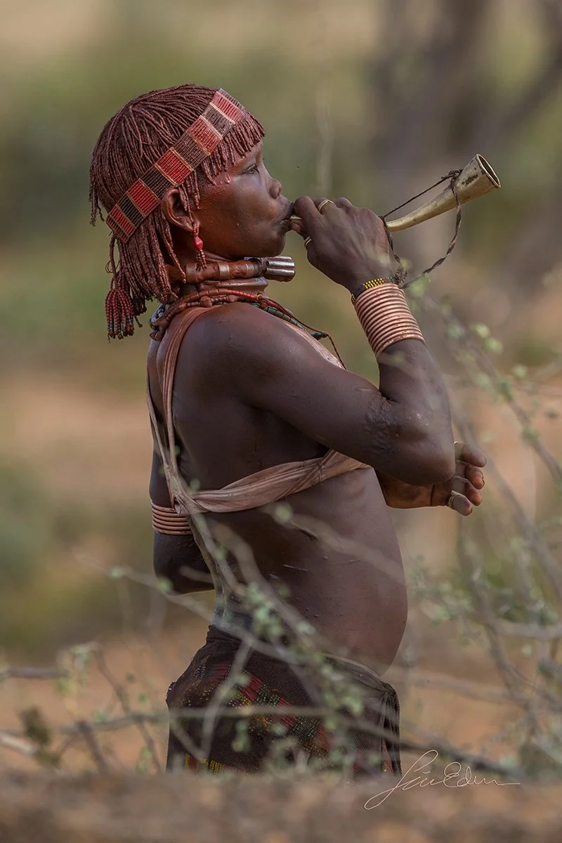 A woman blowing horn and dancing to celebrate a wedding. 