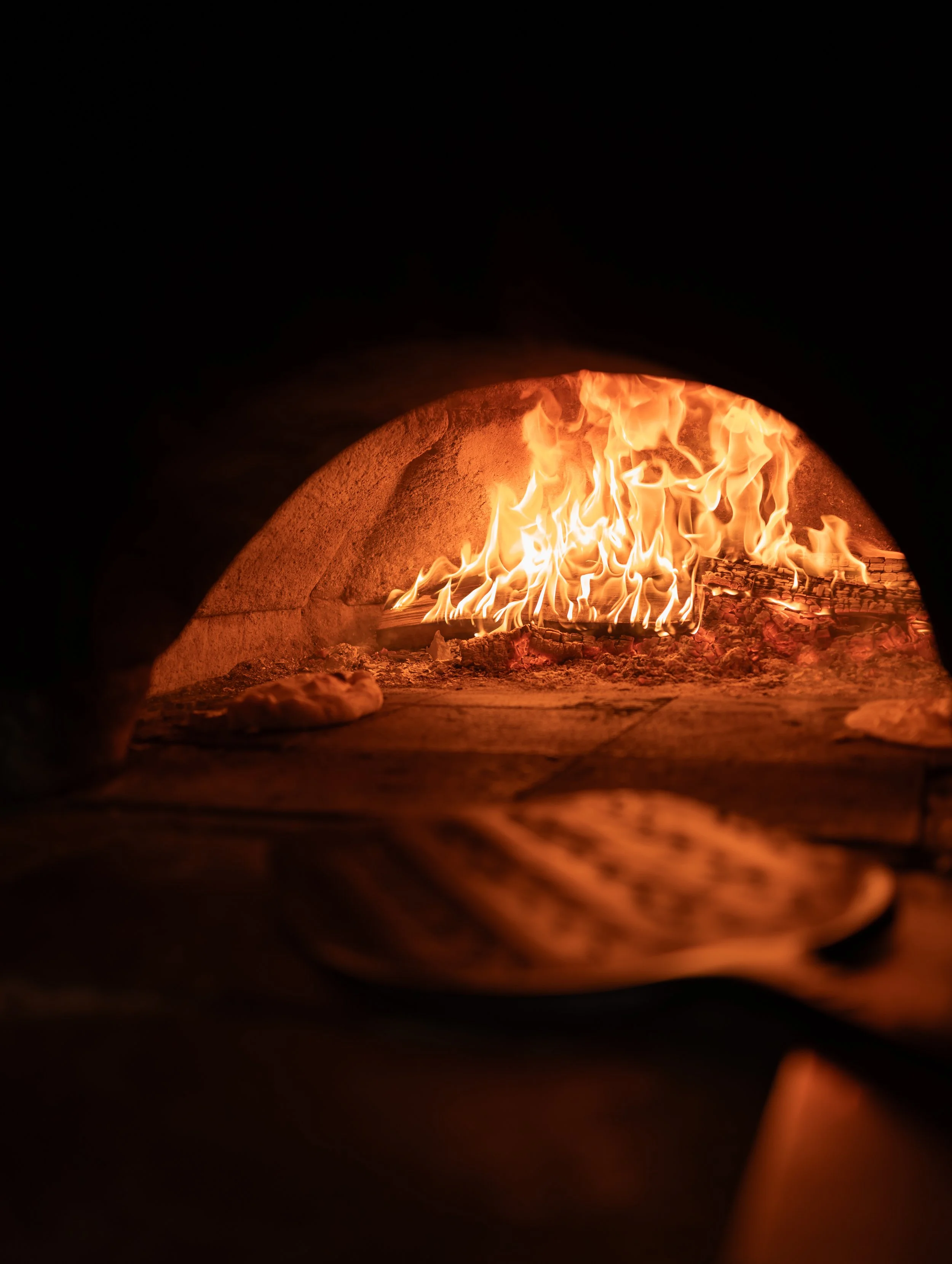 Wood-fired oven with flames inside.