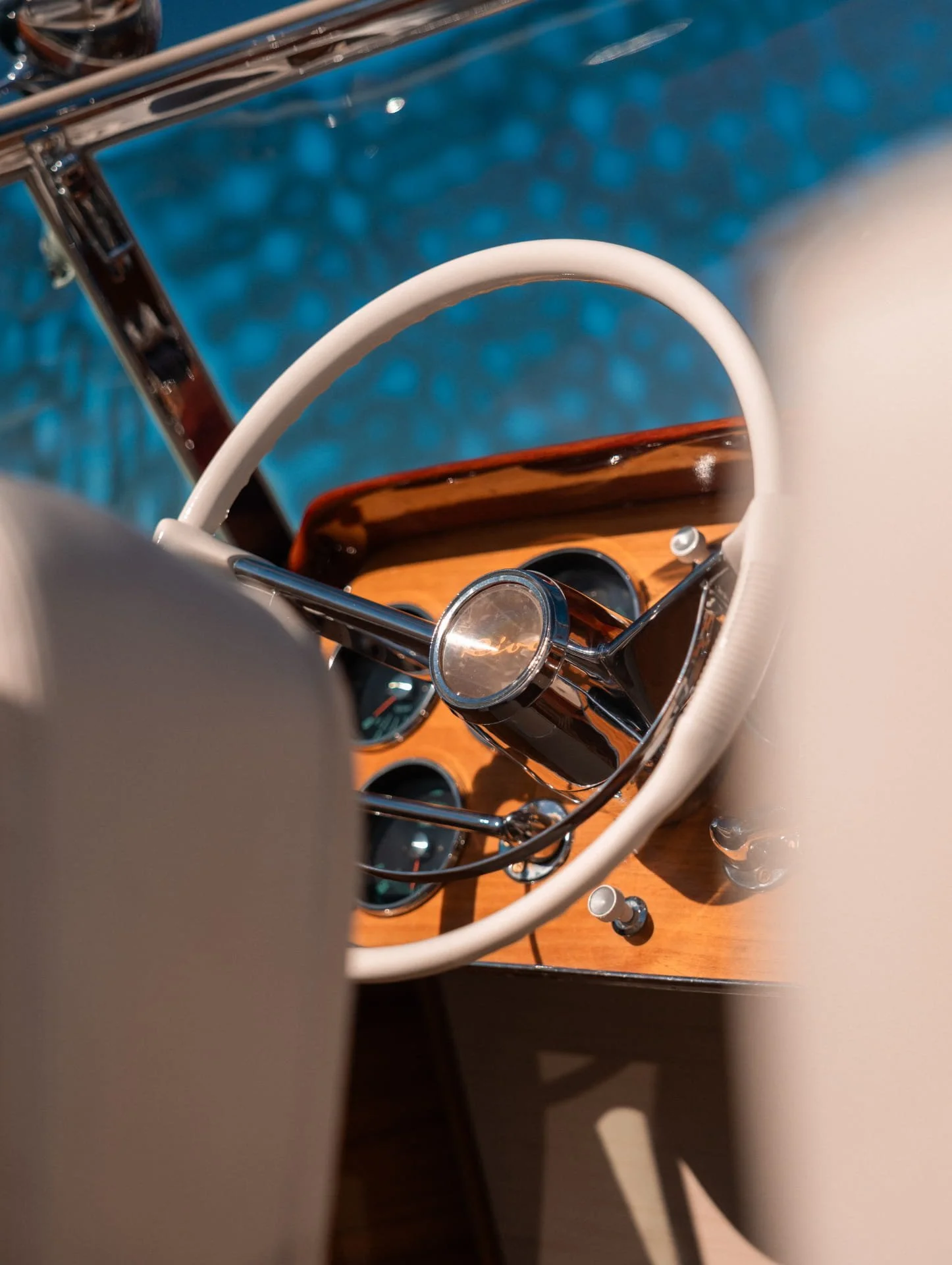 A view of a bicycle handlebar and front light, with the bicycle resting on a wooden surface. The background appears to be water, giving a nautical or boat-like context.