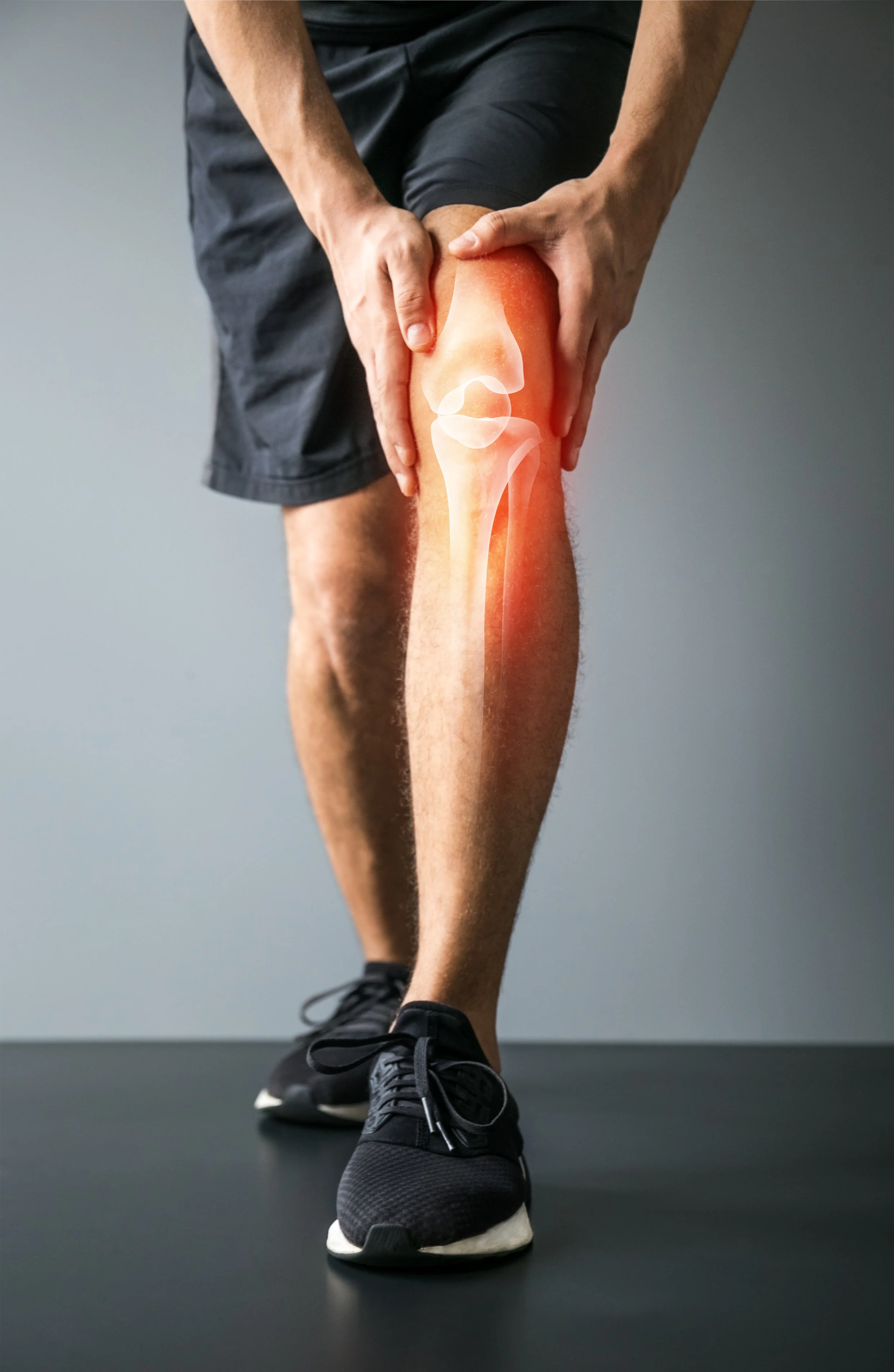 A person holding their knee, with an illustration of a knee joint overlayed on their leg, indicating knee pain or injury.
