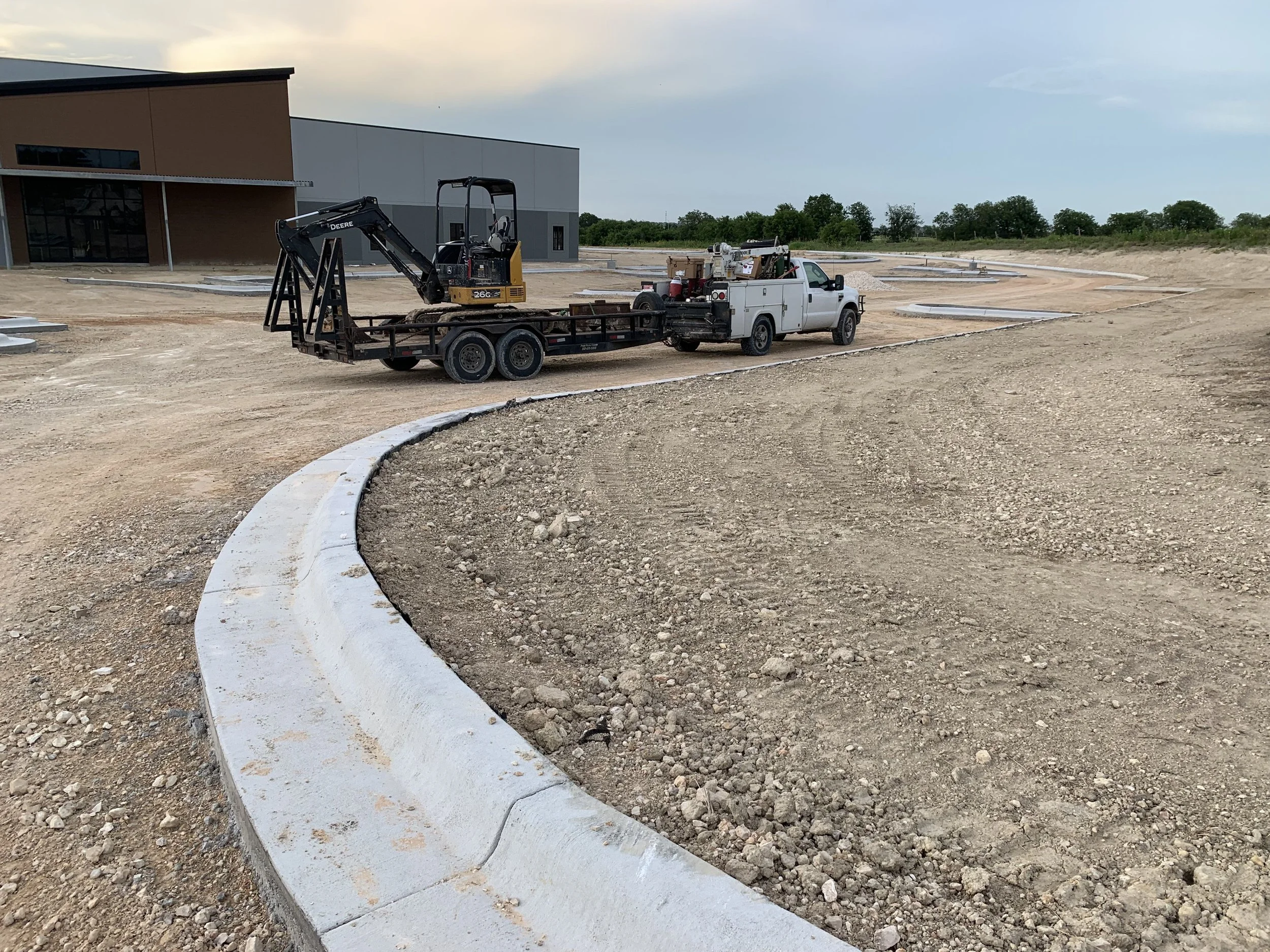 Hippos Construction equipment performing precision grading and subgrade preparation for concrete curbs in Hutto, Texas.