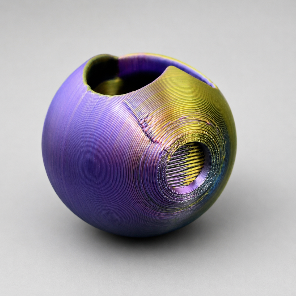 Side view of a color-shifting 3D printed Heart Hollow hide with a rounded opening for a jumping spider enclosure.