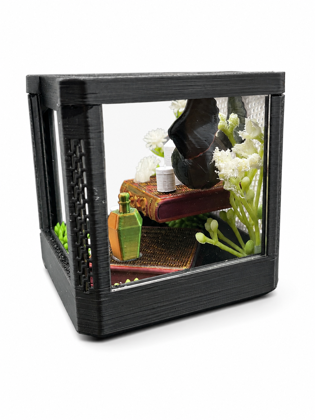 Front view of The Seeker’s Study one-of-a-kind fantasy jumping spider enclosure with books, potions, candles, flowers and greenery.