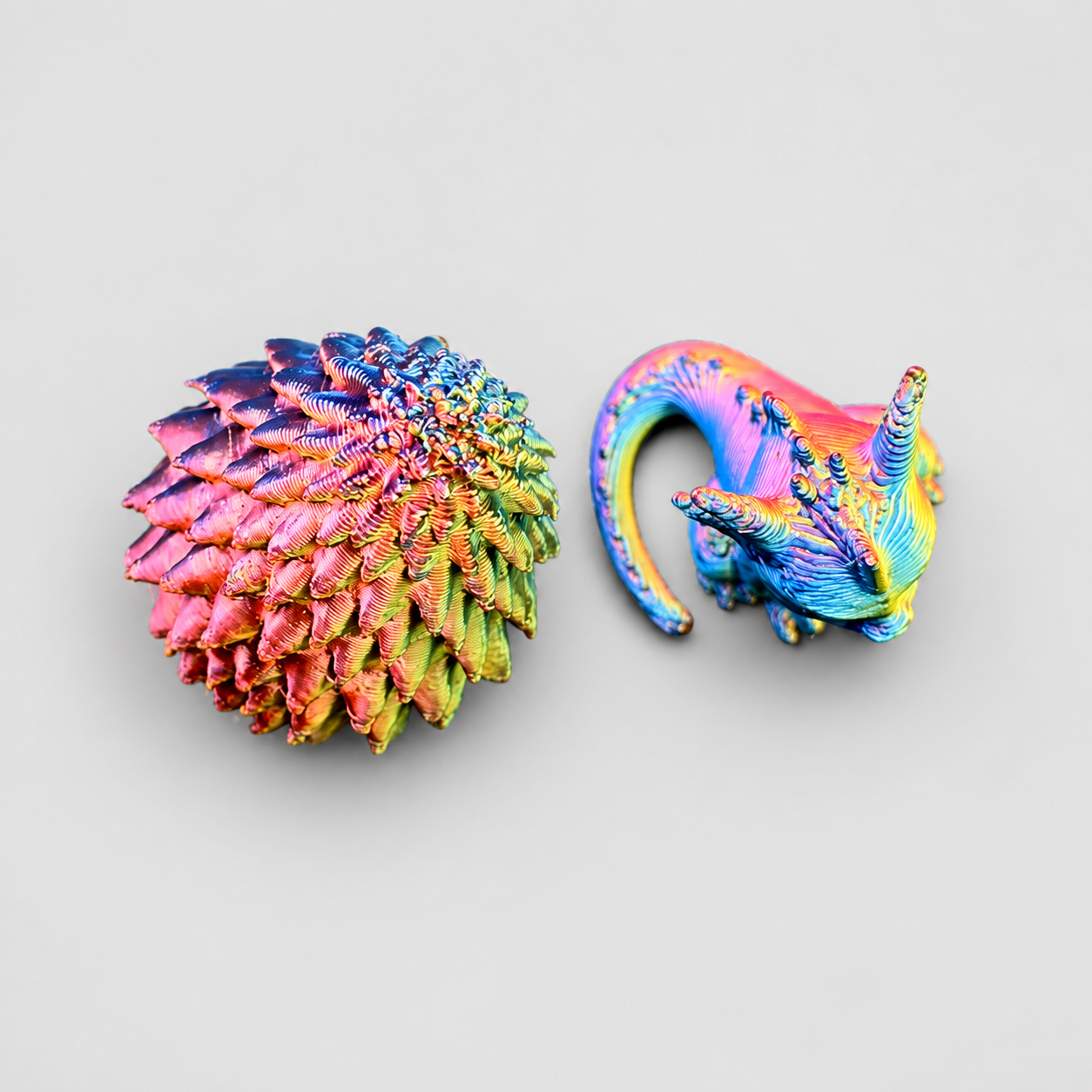 Tiny color-shifting 3D printed baby dragon and textured dragon egg set for fantasy jumping spider enclosure decor.