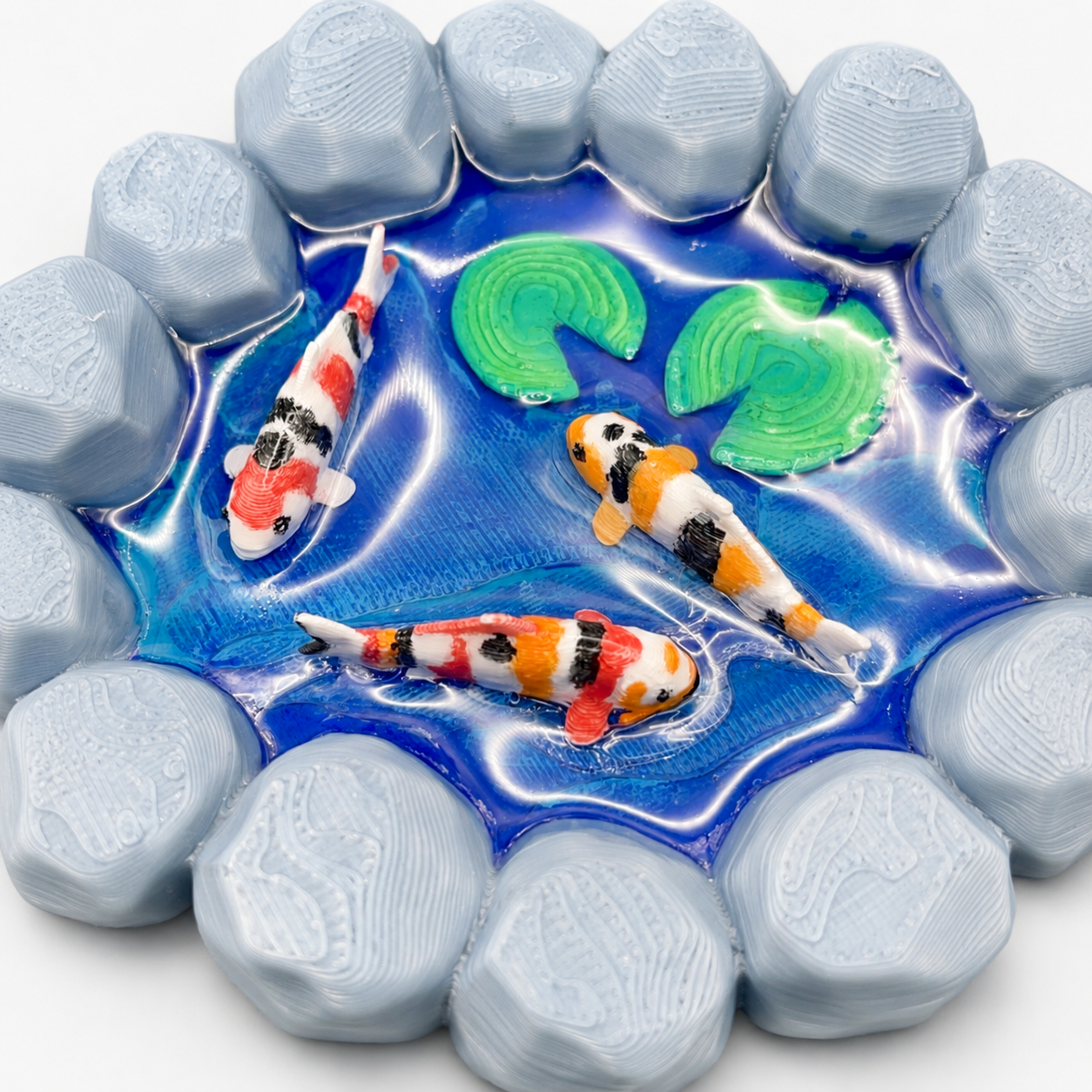 Angled view of The Wishing Pond miniature koi pond with hand-painted koi fish, lily pads, stone edging and individually poured UV resin water.