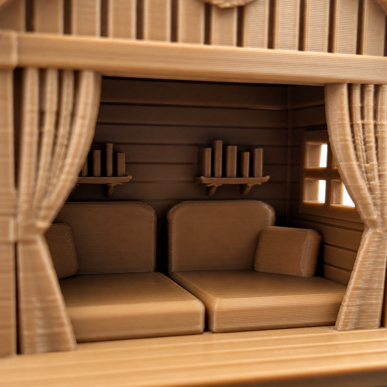 Close-up interior of The Cozy Loft showing miniature chairs, bookshelves, curtains and a window inside the jumping spider hide.