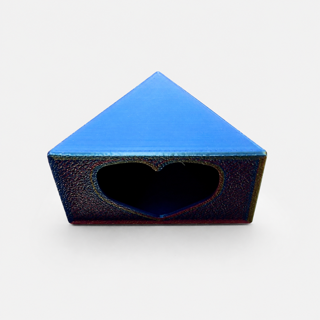 Close front view of a color-shifting 3D printed Love Nest hide with a heart-shaped entrance for a jumping spider enclosure.