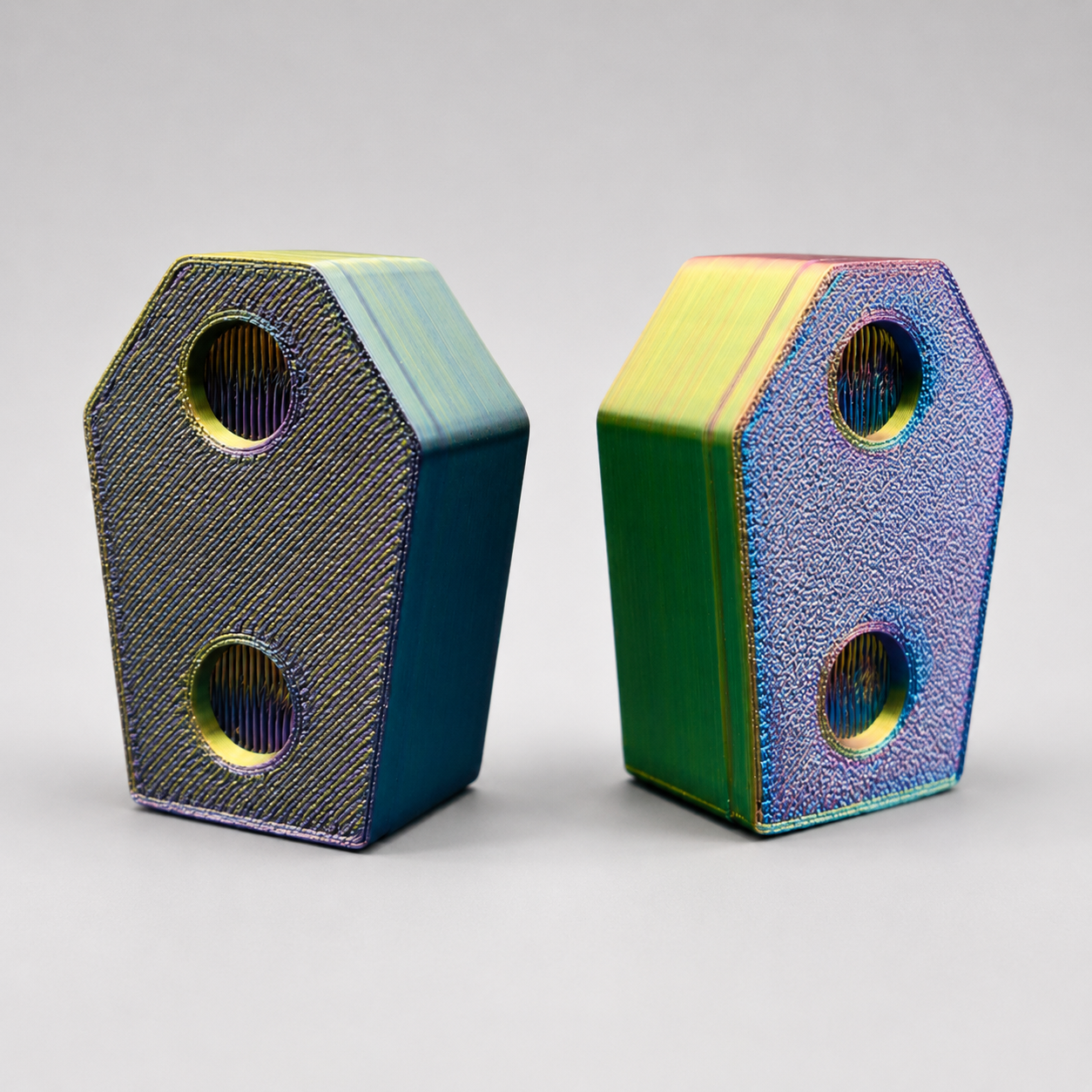 Back view of two color-shifting 3D printed Tiny Crypt coffin hides with mounting spaces for a jumping spider enclosure.