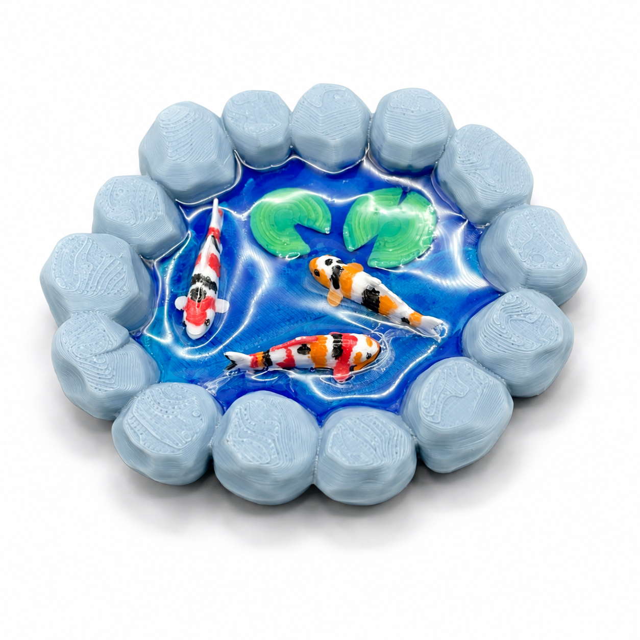 Close view of The Wishing Pond, a handmade miniature 3D printed koi pond with hand-painted koi fish, lily pads and glossy UV resin water for jumping spider enclosure decor.