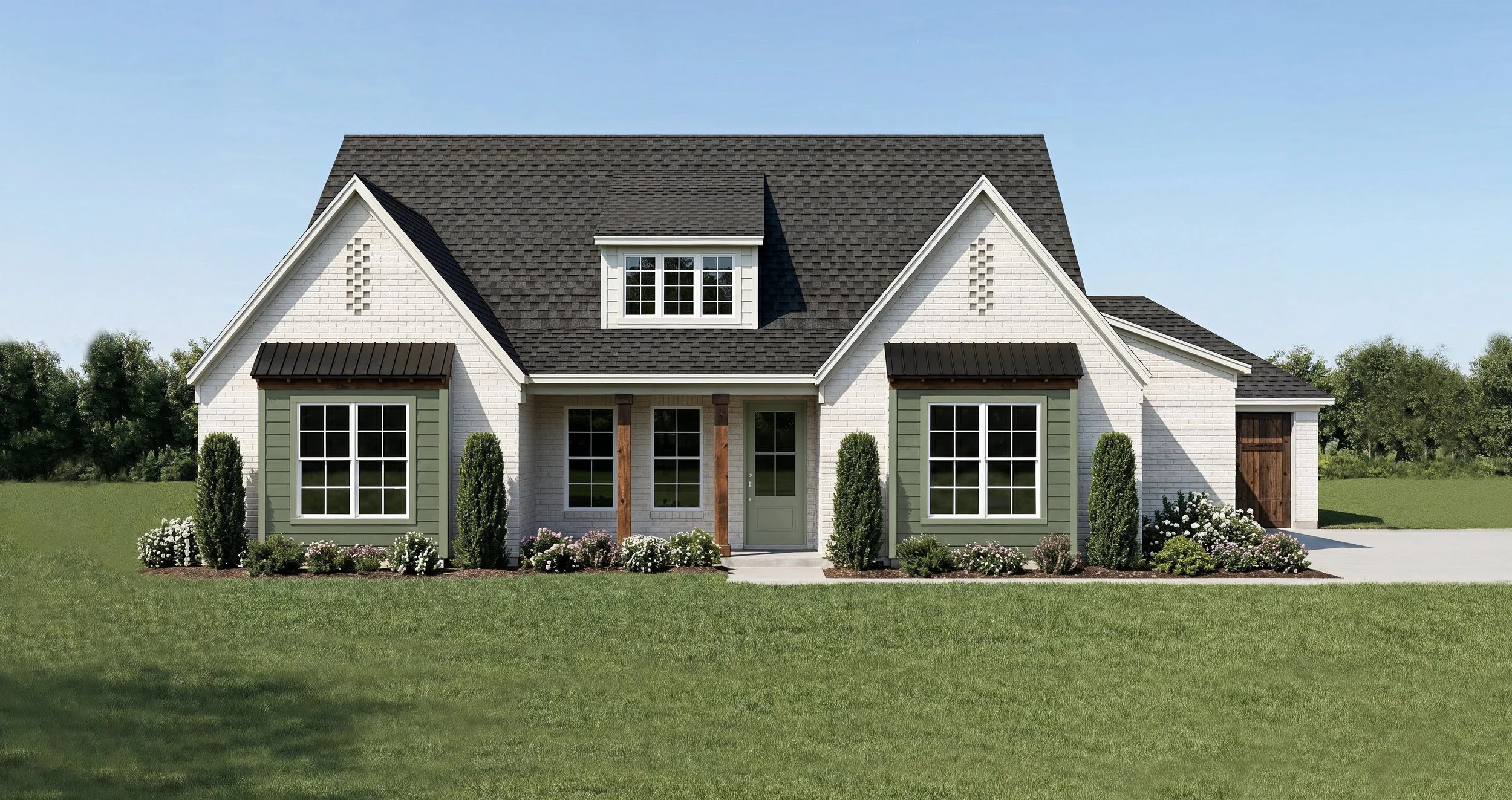A modern two-story house with white brick exterior, green accents, and a dark gray roof. It has multiple large windows, a small front porch with wooden support beams, and landscaped flower beds with bushes and flowers in front. The house is situated on a green lawn with trees in the background and a clear blue sky.