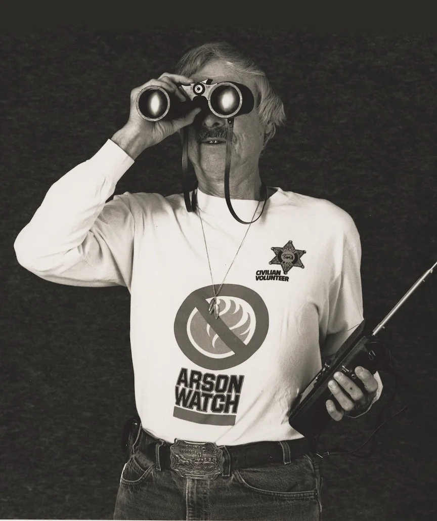 Image of Arson Watch Co-Founder Allen Emerson looking through binoculars and holding a radio provided by Topanga Historical Soceity