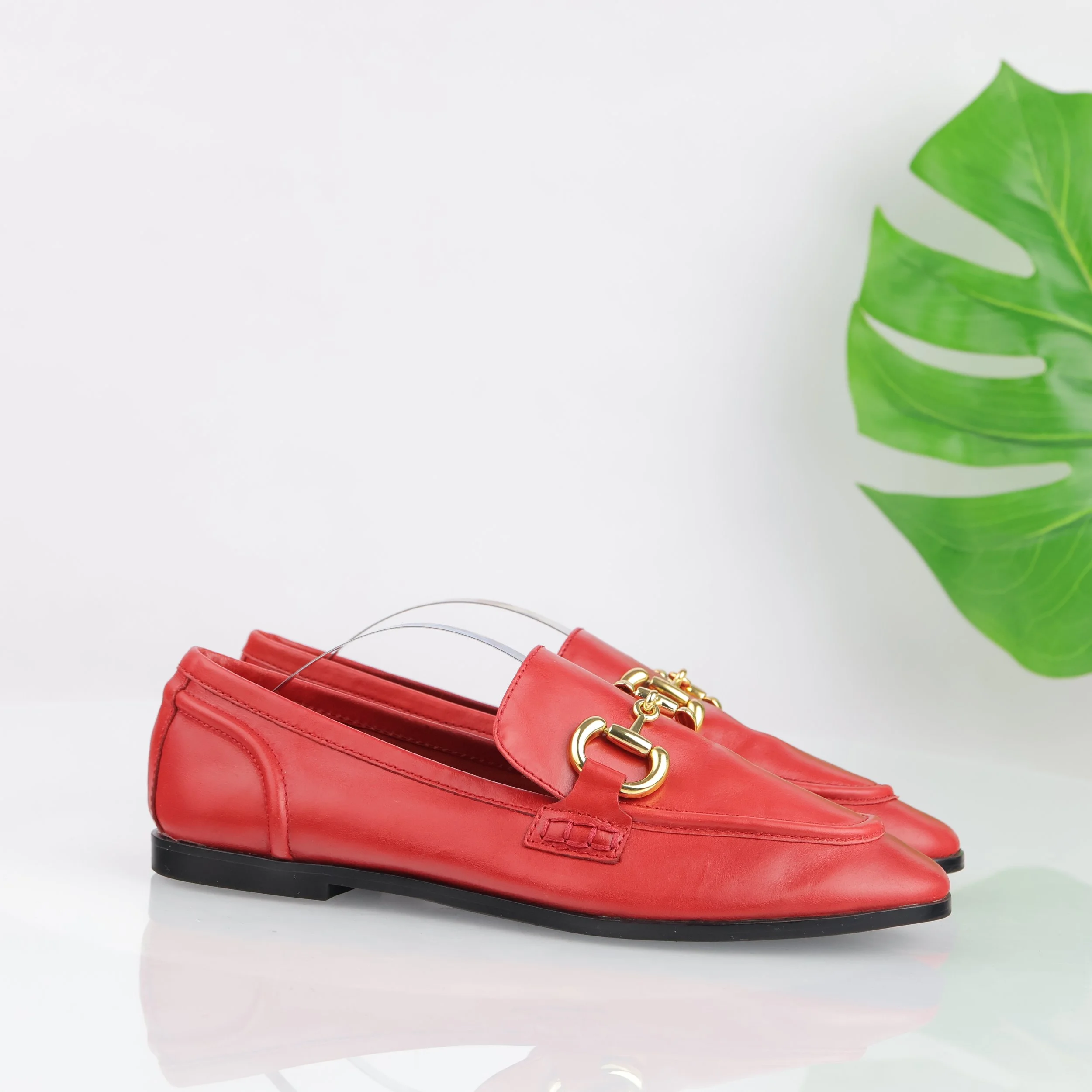 Red loafer with gold-tone hardware.