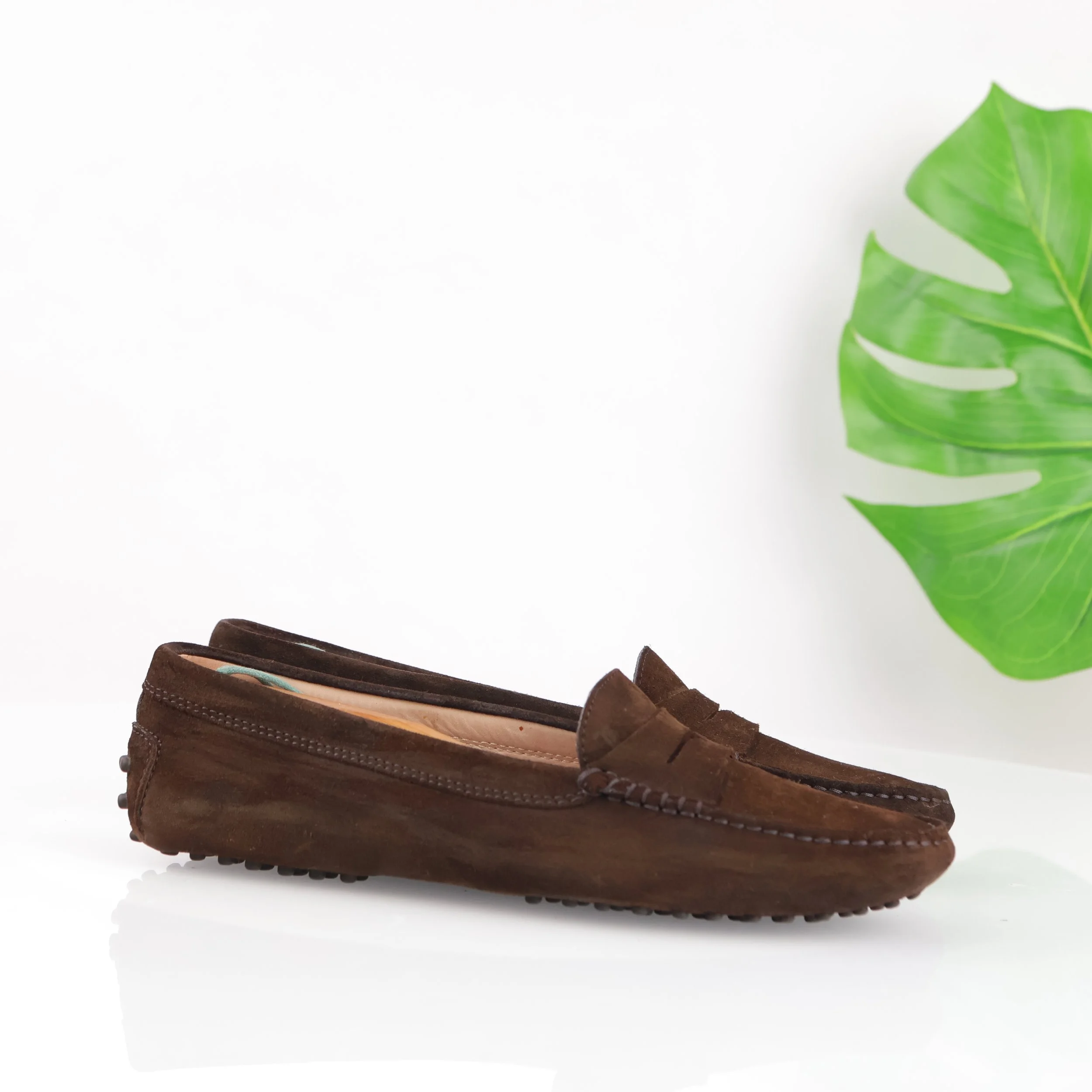 Brown suede loafer with stitched detailing.