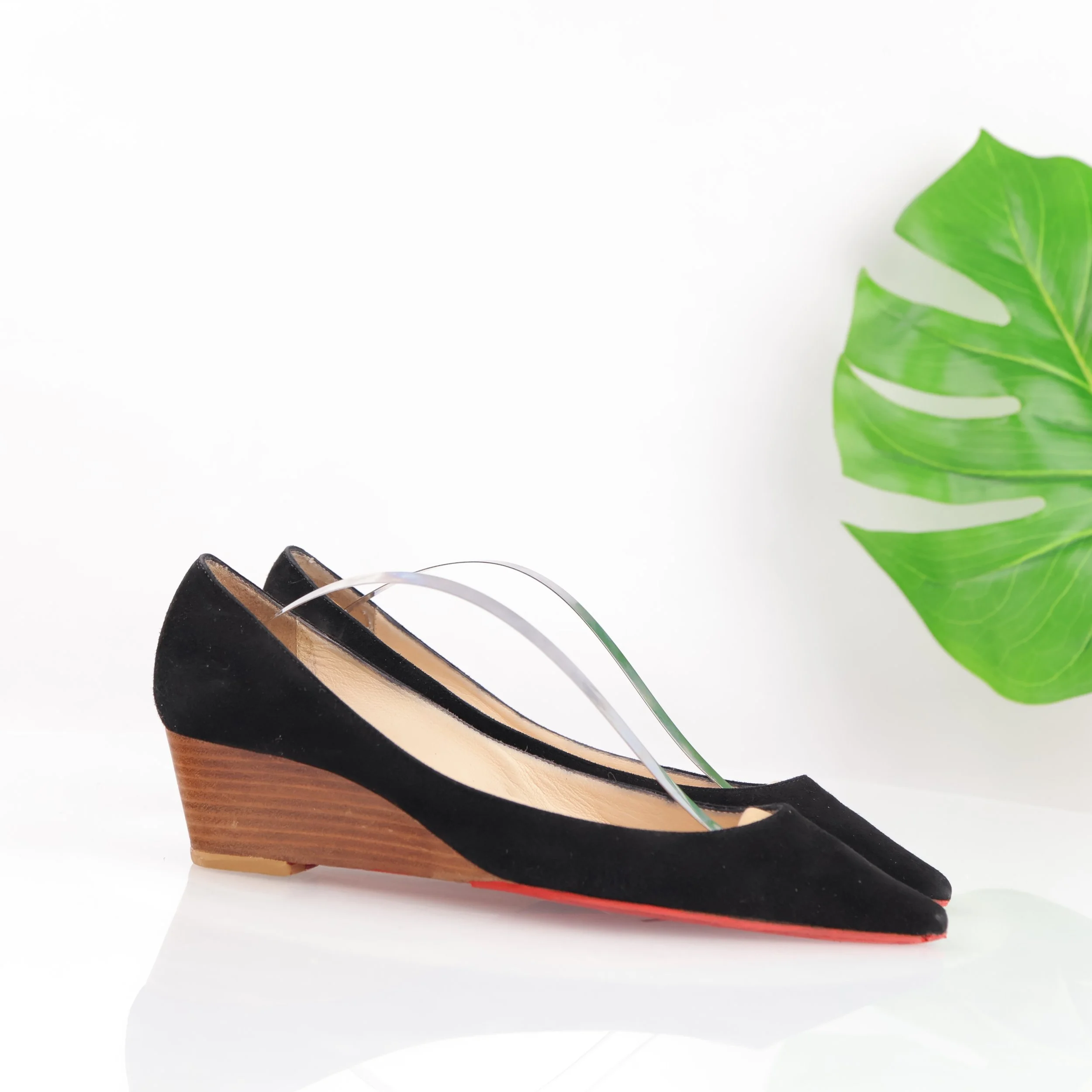 Black pointed-toe wedge pump with striped heel