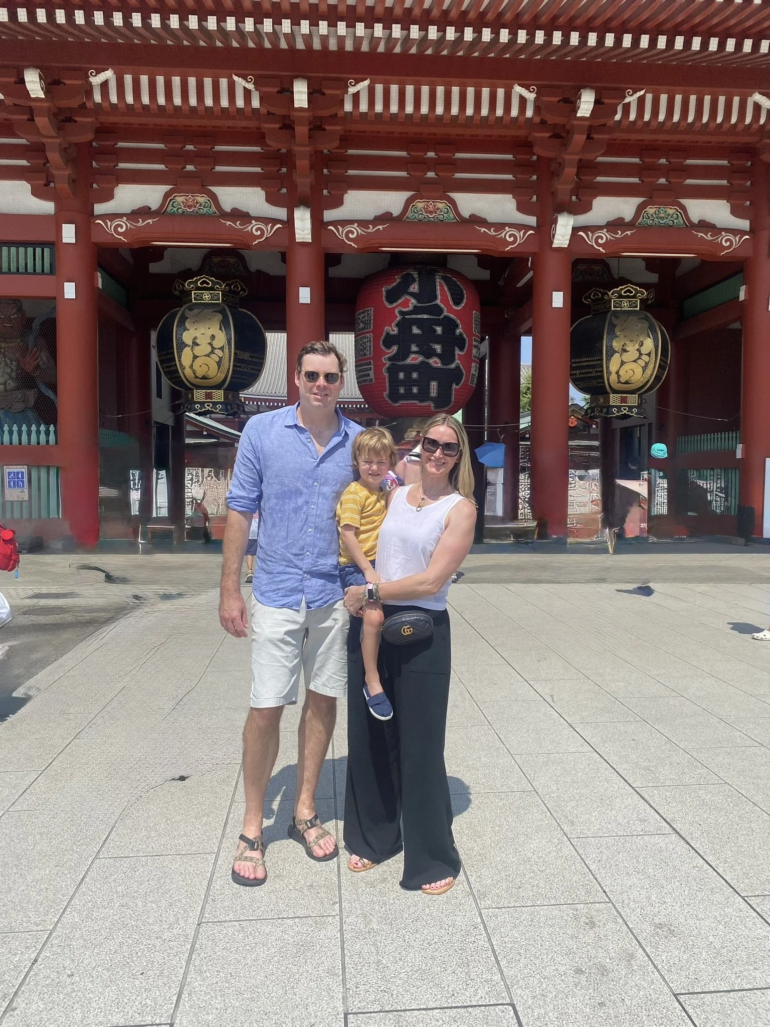 Family of three in front of the red lanterns at Sensō-ji Temple in Tokyo.