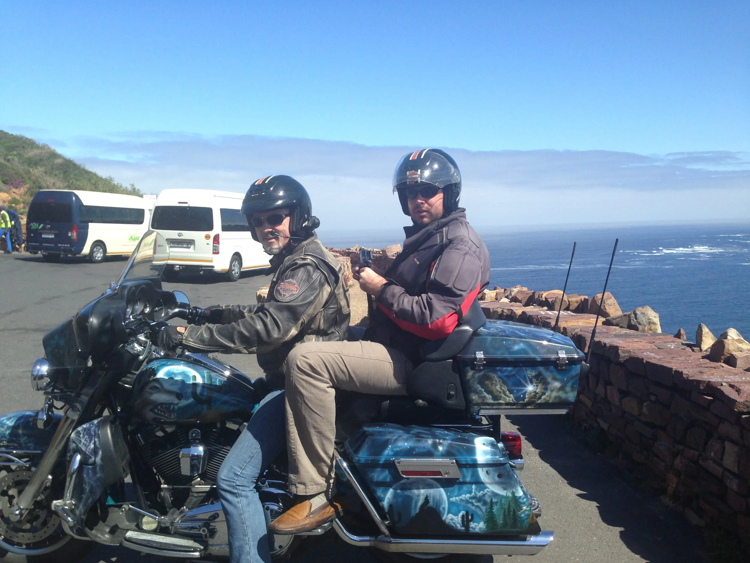 Two motorcyclists posing on a bike at a coastal overlook in South Africa, on the way to the Cape of Good Hope.