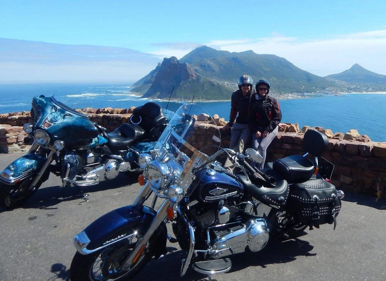 Two motorcyclists beside their bikes at a coastal overlook on the ride to the Cape of Good Hope.